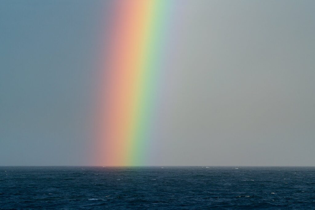 bright rainbow over rippling sea