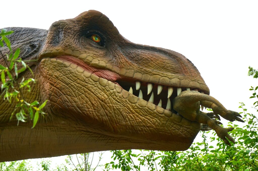 low angle photo of dinosaur eating baby dinosaur